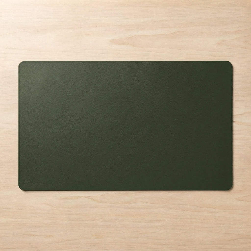 A dark olive green rectangular desk mat with rounded corners, laid flat on a light-colored wood grain surface.