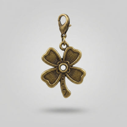 An antique bronze four-leaf clover charm with a lobster clasp, shown against a neutral light gray background.
