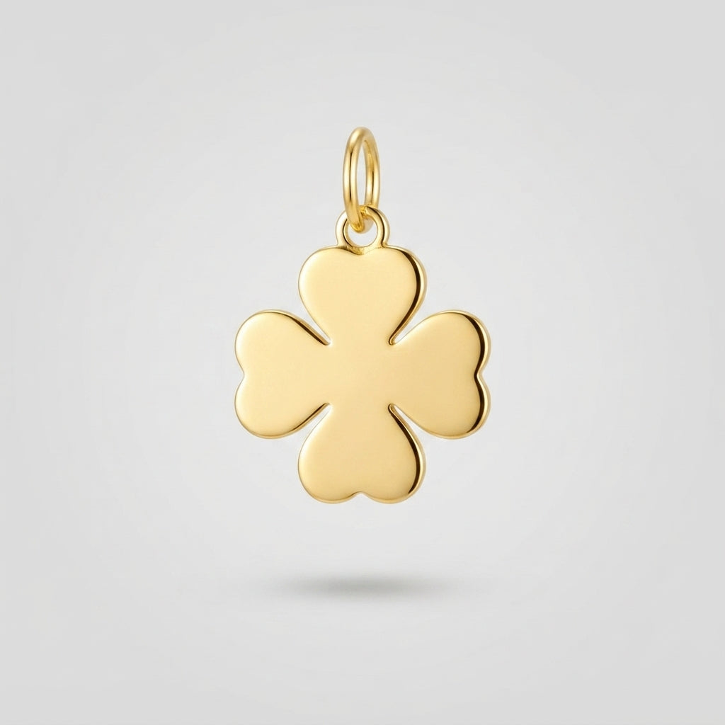 A polished yellow gold four-leaf clover charm pendant with a small top loop, shown against a light gray background.